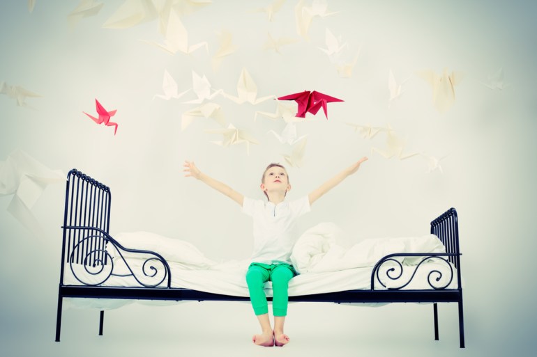 little boy in bed with birds